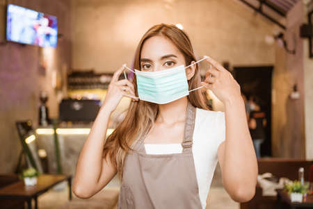 Waitress wearing a face mask at the coffee shopの写真素材