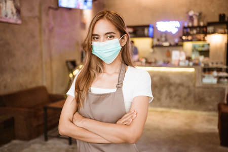 Waitress wearing a face mask at the coffee shopの写真素材