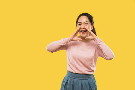 beautiful asian girl shouting two hands beside mouthの写真素材