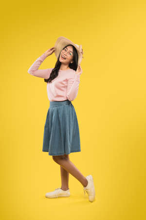 portrait of beautiful young woman in glasses and hat smiling while standing relaxedの写真素材