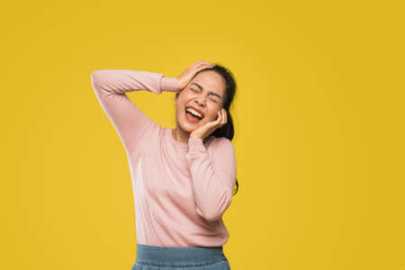 stressed woman screaming with two hands squeezing face and headの写真素材