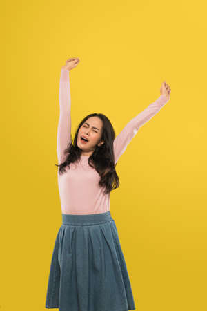 woman yawning with hands raised up with expression waking upの写真素材