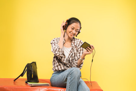 girl headphones playing game using a mobile phoneの写真素材