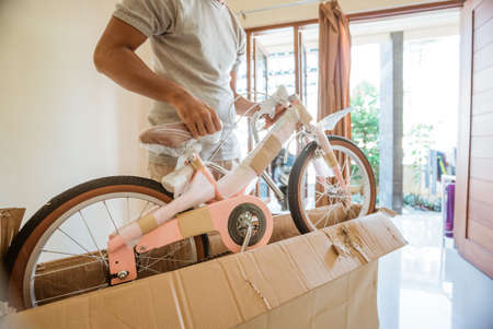 A man unboxing and removing a mini bikeの写真素材