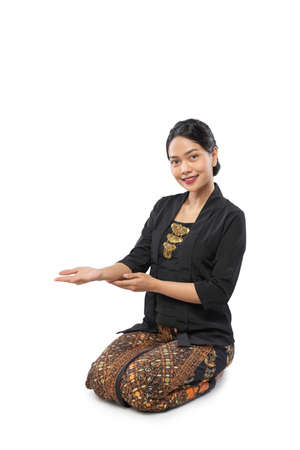 beautiful woman wearing traditional Javanese clothes presenting invitingの写真素材