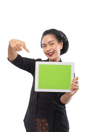 happy asian woman with kebaya showing tablet screenの写真素材