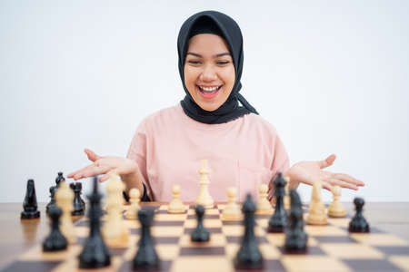 Happy veiled woman with right move while playing chessの写真素材