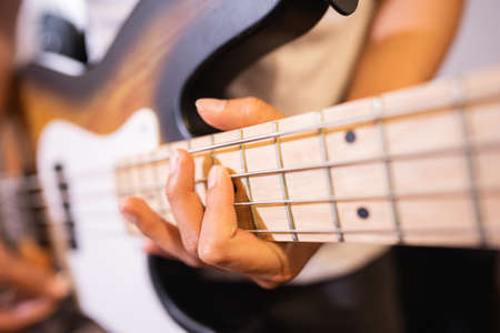 close up of a bassists hand with tapping technique playing electric guitar bassの写真素材