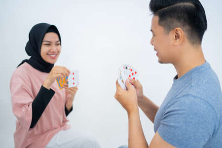 man holding cards while playing cards with a female friendの写真素材