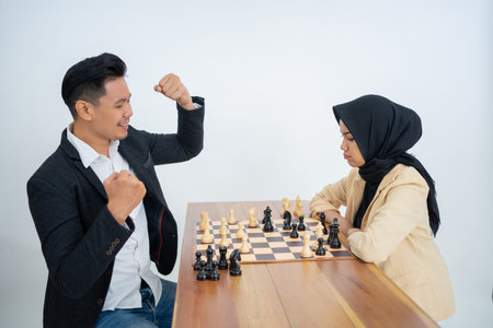 man in suit facing woman with veil while playing chessの写真素材