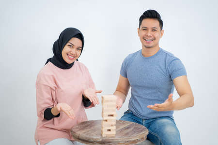 Woman and man with hand gesture presenting playing wooden blockの写真素材