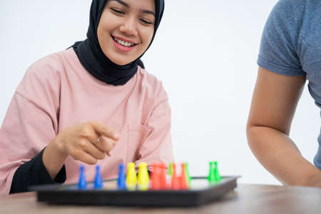Woman with pointing hand playing ludo on boardの写真素材
