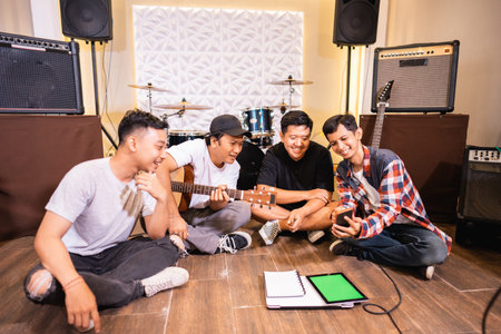 band members chat together sitting on the floor composing songs
