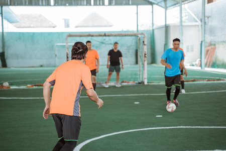 Players in orange uniforms are ready to snatch the ballの写真素材