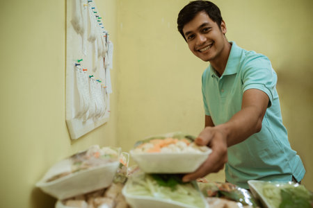 Seller putting fresh vegetables wrapped in plastic wrapの写真素材