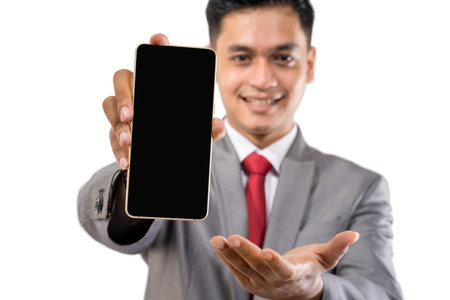 happy smiling businessman showing his mobile phone screen to cameraの写真素材