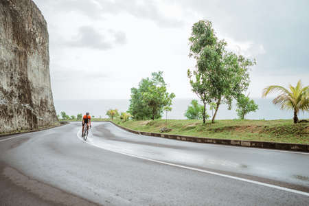 male riding a road bike in beautiful country roadの写真素材