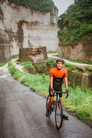 happy smiling road bike cyclist while riding his bike outdoorの写真素材