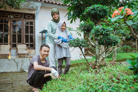 Asian boy smiling while with family gardening in home gardenの写真素材