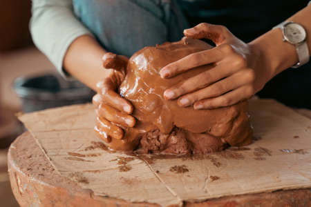 close up of shaping holding wet clay on wheelsの写真素材