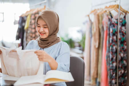 muslim fashion designer checking her dress productの写真素材
