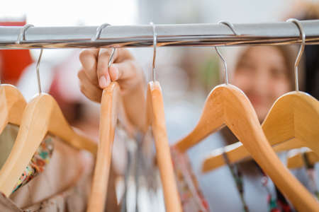 hand gesture taking clothes hanger at fashion storeの写真素材