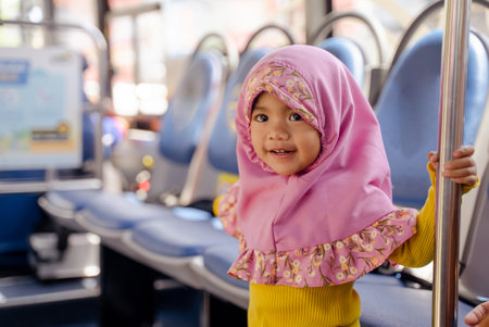 muslim little girl with hijab riding busの写真素材
