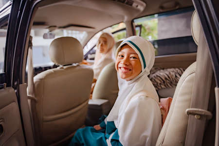 muslim smiling mother taking her daughter to school by carの写真素材