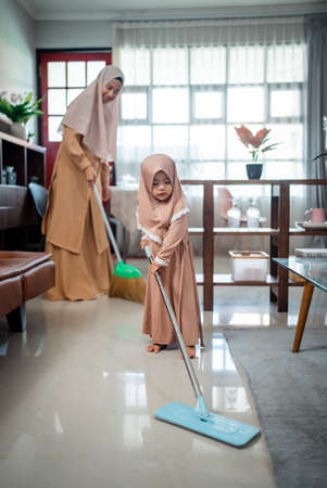 Happy muslim family cleans the room togetherの写真素材