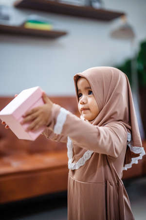 muslim Child daughter holding a gift boxの写真素材
