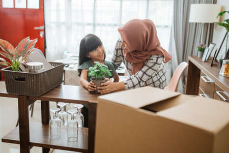 muslim mother and daughter decorating her house with indoor plantsの写真素材