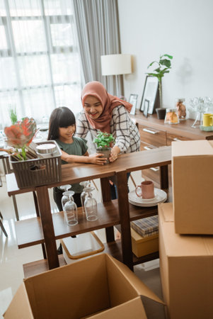muslim mother and daughter decorating her house with indoor plants