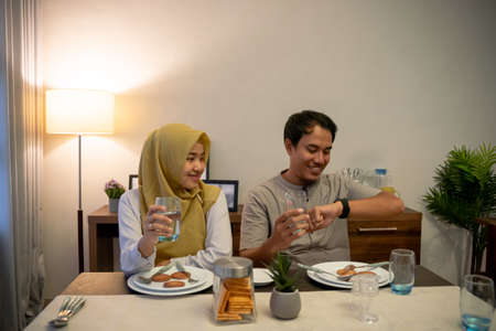 muslim couple waiting adhan to break the fastの写真素材