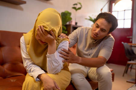 muslim male comforting his wifeの写真素材