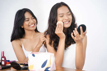 beautiful happy asian friend while doing make up togetherの写真素材