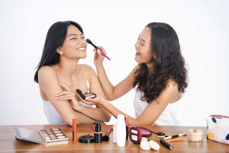 two asian beautiful happy friend while doing make upの写真素材