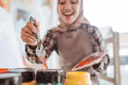 muslim Female artist painting on canvas at home studioの写真素材