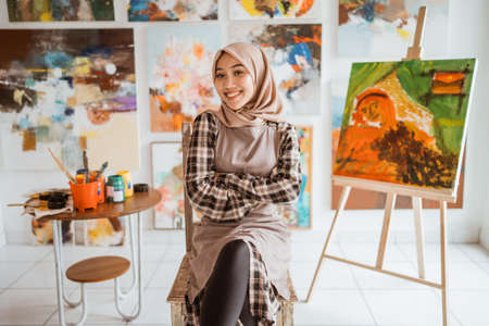 muslim female painter painting on canvas in her workshopの写真素材