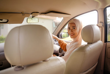 beautiful young muslim woman driving a car
