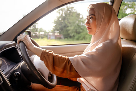 beautiful young muslim woman driving a car