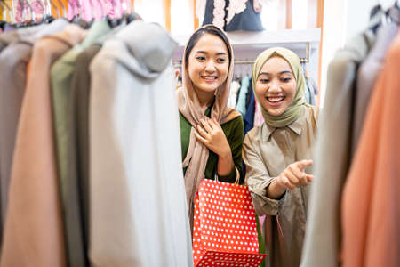 muslim female friend buying new dress at fashion storeの写真素材
