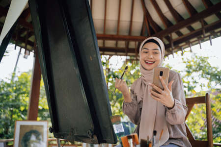 muslim painter is painting in her workshop excitedlyの写真素材