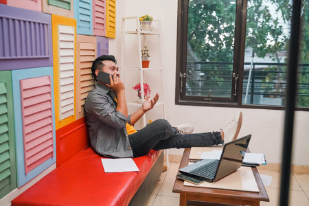 young asian man talking on phone while discussing