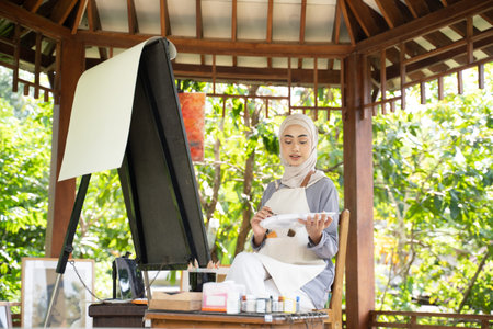 muslim Female artist painting on canvas at home studio
