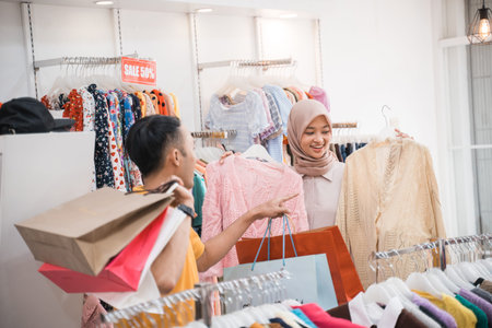 couple with shopping bags in the fashion store buying new clothesの写真素材