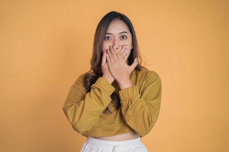 Young woman with shocked expression with hands covering mouth
