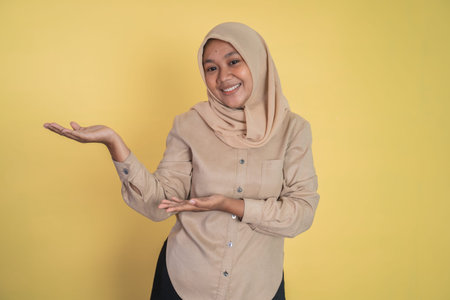 Young hijab woman with hand gesture presenting something