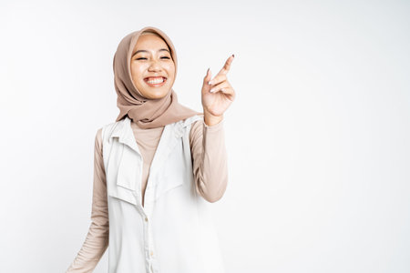 Smiling hijab woman with finger pointing up hand gesture