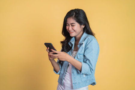 Young asian woman using mobile cell phone typing sms message
