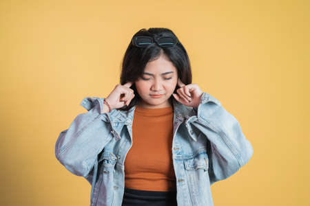 depressed young woman covering ears with fingersの写真素材